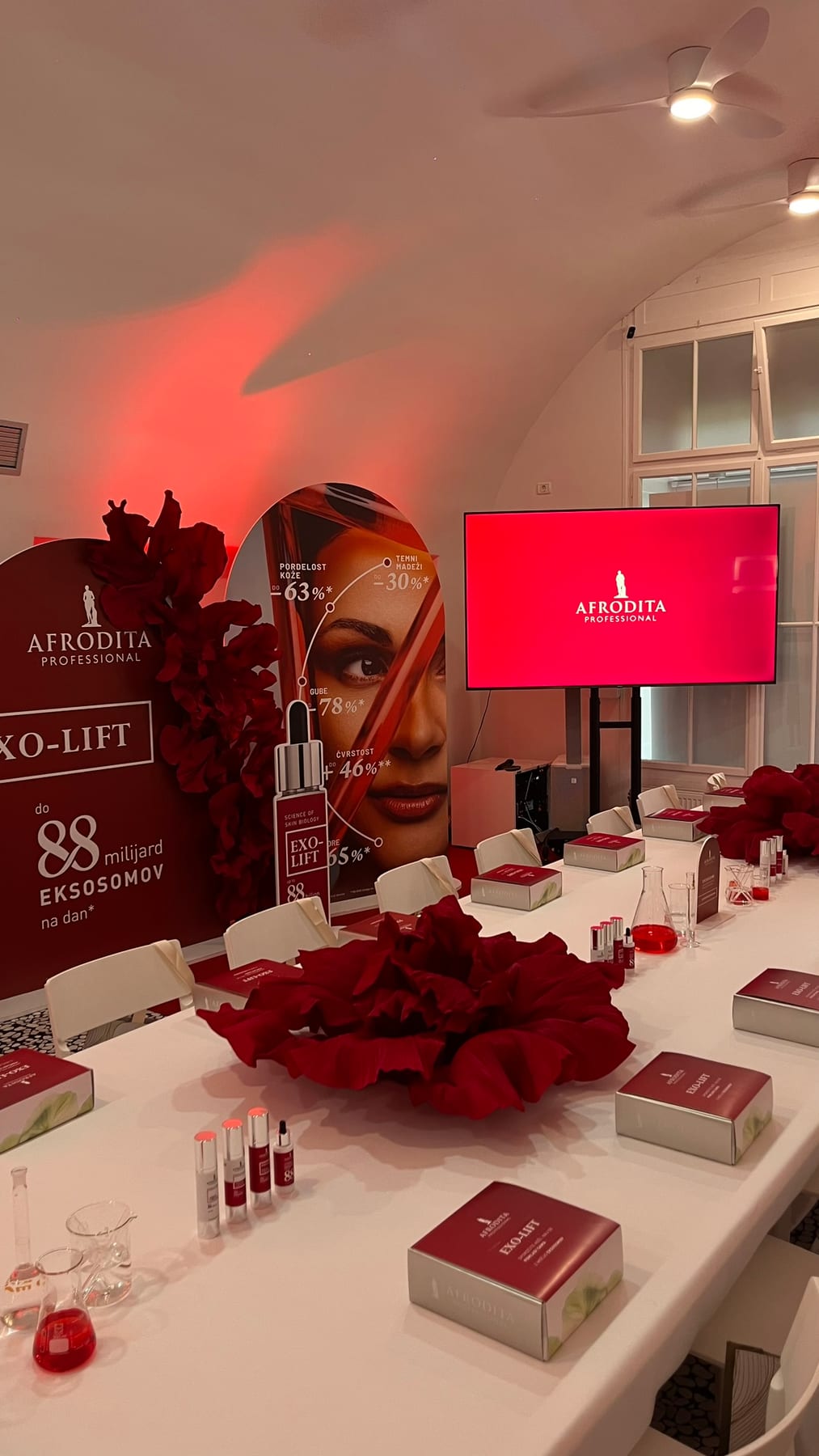 369 Place Ljubljana — Afrodita Professional EXO-LIFT lansiranje, brandirana postavitev z rdečimi cvetovi